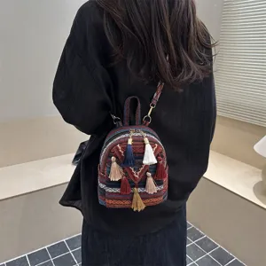 Ethnic style woven mini backpack detail view, featuring colorful tassels and adjustable straps.