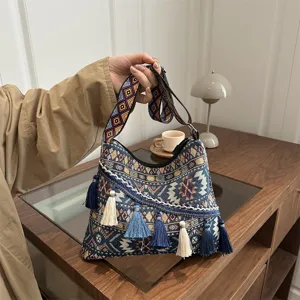 Woven ethnic style shoulder crossbody bag detail, featuring colorful geometric strap and delicate tassels.