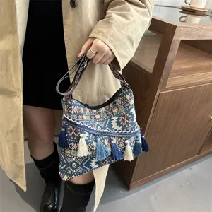 Retro ethnic style women shoulder crossbody bag with woven fabric and chic tassel decor.