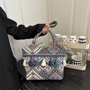 Detailed view of the ethnic embroidered tote bag featuring traditional tassels and patterned fabric.