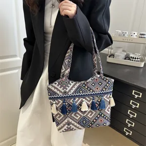 Ethnic style woven shoulder bag detail, geometric pattern with multi-color tassels.
