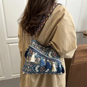 Ethnic style embroidered shoulder crossbody bag with colorful tassels and geometric strap.