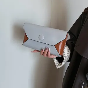 Close-up detail of stylish color-blocked clutch bag, perfect for evening parties and dinners.