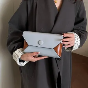 Detailed view of a chic color-block envelope clutch bag, perfect for evening parties.