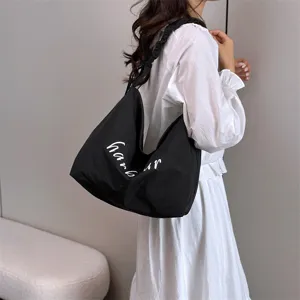 Casual black shoulder bag with white letter print, versatile slouchy tote for daily commute.
