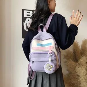 Cute purple canvas backpack detail featuring contrast color straps and a playful bear coin purse.