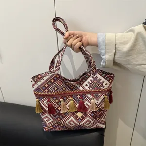 Ethnic style woven handbag with vintage geometric embroidery and decorative tassels for daily use.