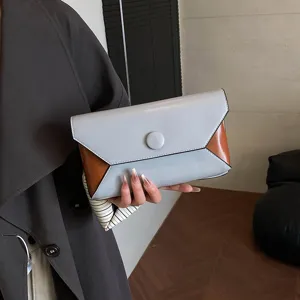 Detailed view of a chic color-block clutch bag with stylish geometric corners and neat buttons.