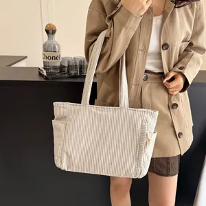 Detail view of a vintage corduroy tote bag in beige, showcasing large capacity and pockets.
