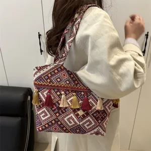 Ethnic style woven tote bag with vintage geometric embroidery and elegant hanging tassels.