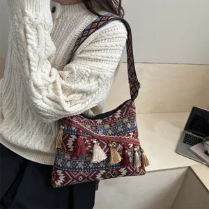 Detailed shot of a vintage ethnic style shoulder crossbody bag with tassel and geometric strap.