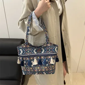 Detailed view of vintage ethnic woven tote bag with fringe tassels and geometric patterns.