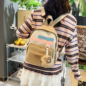 Detailed shot of casual beige mini backpack featuring cute bear pendant and straps.