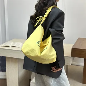 Yellow slouchy shoulder bag for women, casual tote bag with cute letter print and gathered strap.