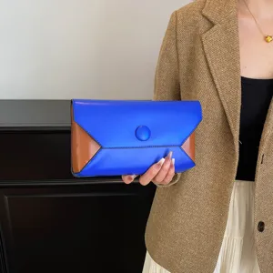 Color block envelope clutch detail shot, showing the contrast leather texture and chic clasp.