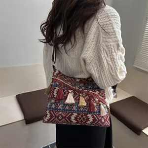 Detail view of ethnic style woven shoulder bag with colorful tassels and geometric patterns.
