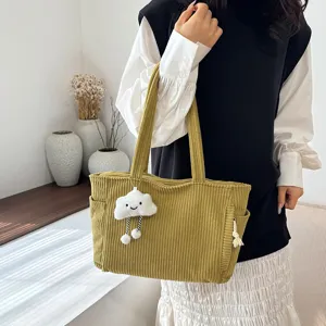 Corduroy tote bag detail showing large capacity, soft texture and cute cloud pendant.