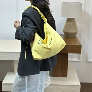Yellow slouchy shoulder bag with crinkled strap and stylish green letter print casual tote