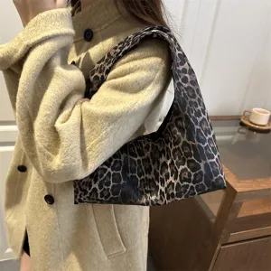 Close-up detail shot of a stylish leopard print shoulder bag worn in a cozy setting.