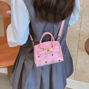Pequeño bolso bandolera rosa en miniatura con estampado de osito, cierre metálico y correa.