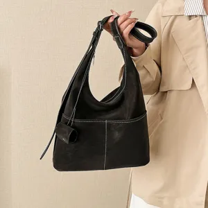 Detailed view of dark retro suede hobo shoulder bag with contrast white stitching and mini pouch.