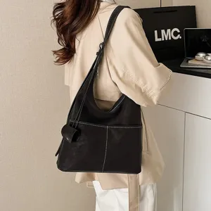 Detailed view of retro suede shoulder hobo bag, showing fine white stitching and large capacity.