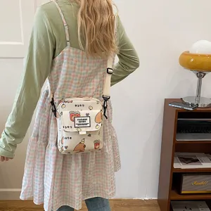 Canvas crossbody bag with cute cartoon capybara print, adjustable strap and flap closure.
