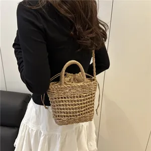 Detailed view of summer woven straw bucket bag showcasing texture and drawstring interior.