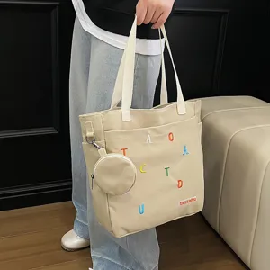 Canvas tote bag detail view, beige shoulder bag with colorful embroidered letters and coin purse.
