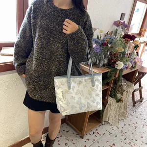 Detailed view of the women's casual butterfly jacquard tote bag with comfortable blue handles.