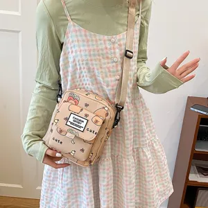 Detail view of canvas crossbody bag with cute capybara print and front pocket design.