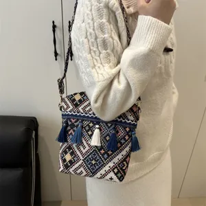 Sac bandoulière tissé géométrique de style ethnique avec pampilles, vue détaillée du design.