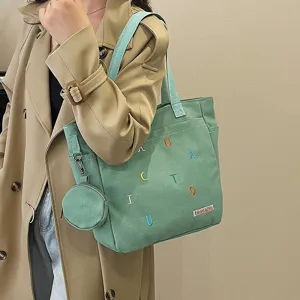 Canvas tote bag detail view, green shoulder bag with small pouch and colorful embroidered letters.