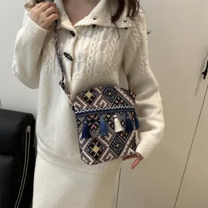 Sac à bandoulière tissé de style ethnique avec motifs géométriques et pompons élégants.