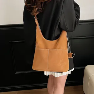 Brown faux suede hobo shoulder bag featuring large capacity and stylish front pockets.
