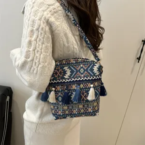 Détail du sac bandoulière tissé style ethnique avec franges vintage et design.