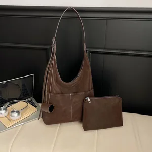 Detail view of retro brown suede hobo shoulder bag with matching clutch for women.