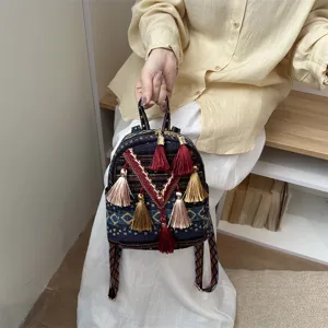 Ethnic woven mini backpack for women, stylish small daypack with colorful tassels and straps.