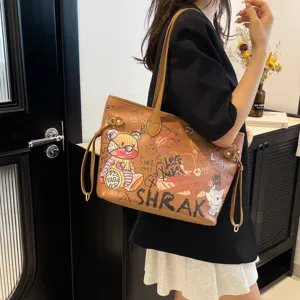 Detail view of brown tote bag with stylish graffiti print, large capacity and shoulder straps.