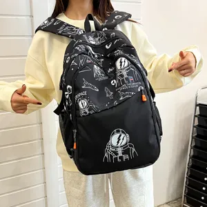 Vista detallada de la mochila negra con graffiti de astronauta y bolsillos con cremallera.
