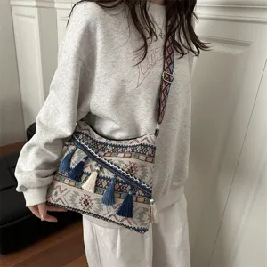 Ethnic style shoulder crossbody bag detail view featuring traditional woven patterns and hanging tassels.