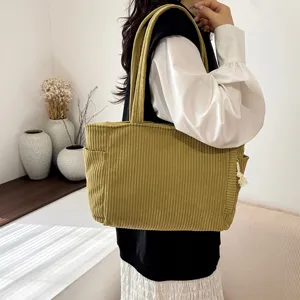 Detailed view of the casual corduroy tote bag showcasing its side pocket and texture.
