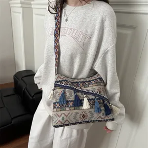 Ethnic style woven canvas shoulder bag with tassels and geometric patterns for women.