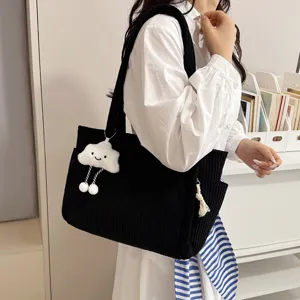 Detailed shot of a women's large capacity black corduroy tote bag, simple retro style.