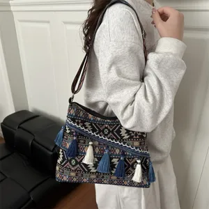 Detailed view of the ethnic style shoulder bag featuring geometric woven patterns and tassel trims.