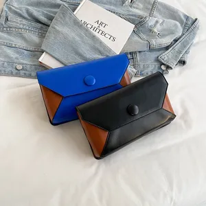 Detailed shot of stylish colorblock envelope clutch bag with unique design for evening party.