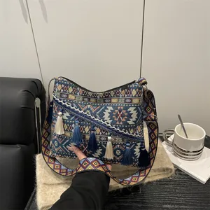 Ethnic style woven canvas shoulder bag with colorful geometric patterns and elegant tassels.