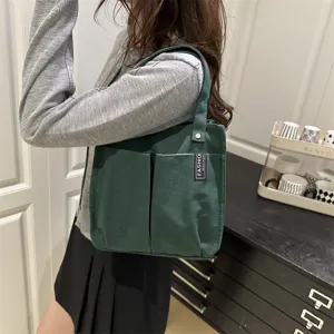 Nahaufnahme der dunkelgrünen Canvas-Tragetasche mit praktischen Vordertaschen und robustem Griff.
