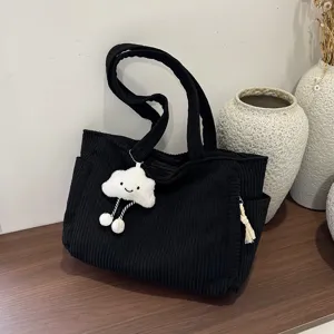 Black corduroy tote bag detail view, large capacity casual shoulder handbag with cute pendant.