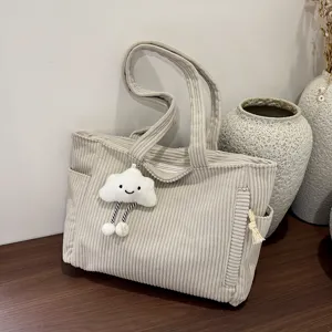 Detailed view of the aesthetic beige corduroy tote bag featuring a cute cloud plush pendant.